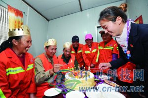 社區(qū)工作人員為集體過生日的三名環(huán)衛(wèi)工人點上生日蠟燭。 本報通訊員 趙松 攝
